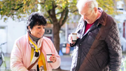 older womand and man drinking coffee outside