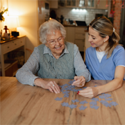 Older woman and nurse a puzzle together