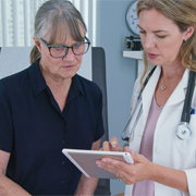 GP with patient, looking at tablet