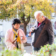 older womand and man drinking coffee outside