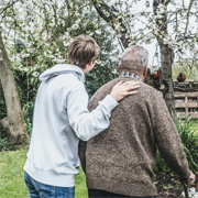An older person and a younger person in a garden